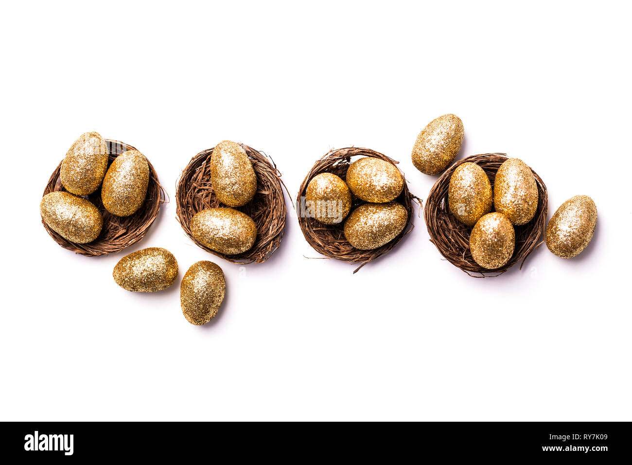 Golden glitter eggs in a nest. Easter background. Finance concept Stock