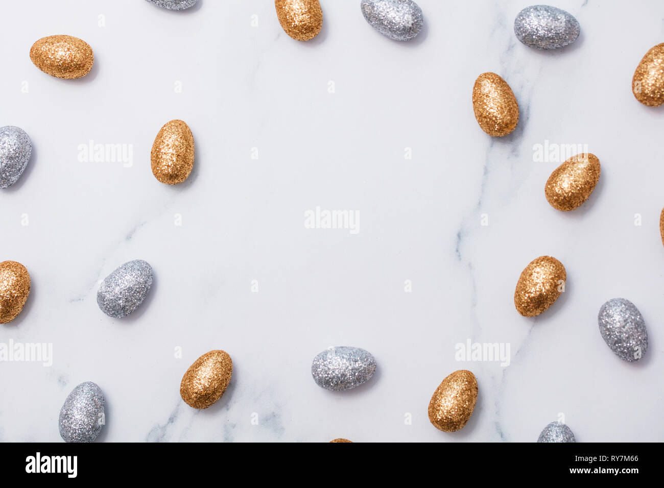 Gold and silver glitter easter eggs on a marble background Stock Photo