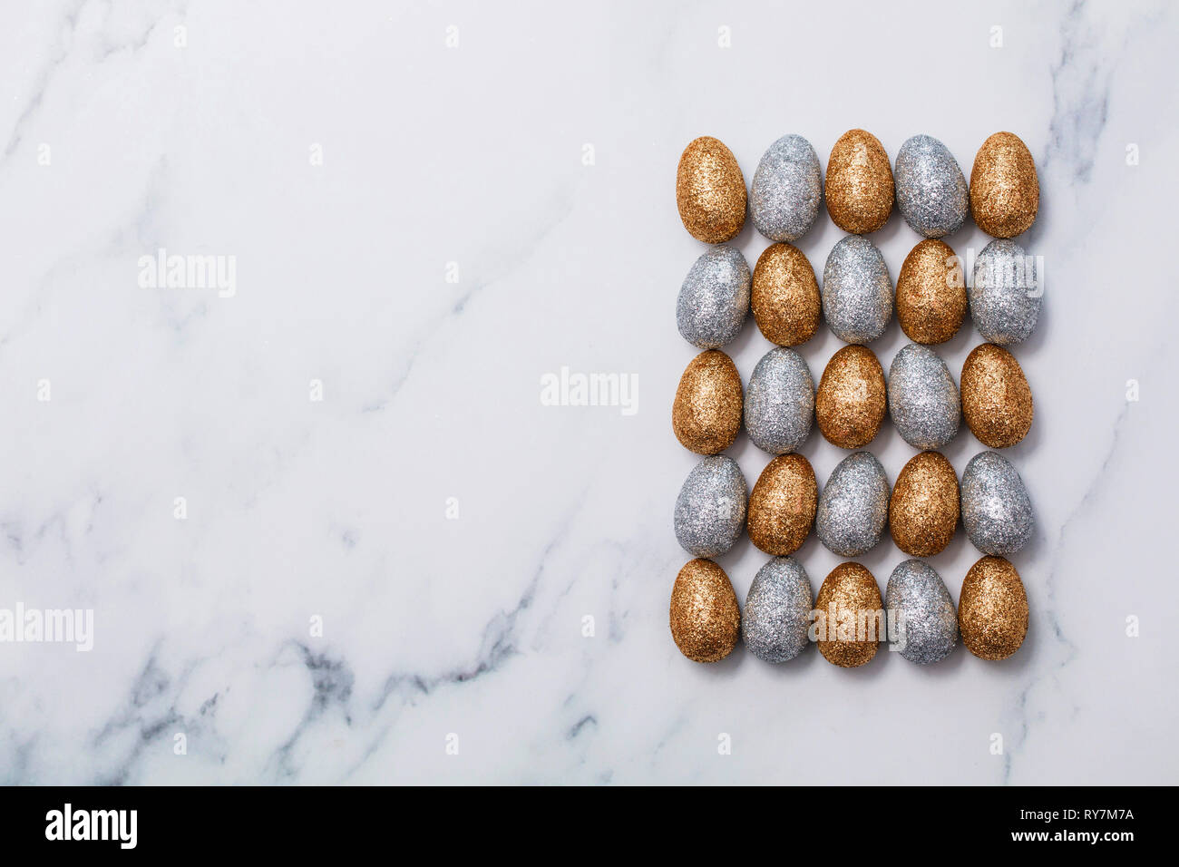Gold and silver glitter easter eggs on a marble background Stock Photo