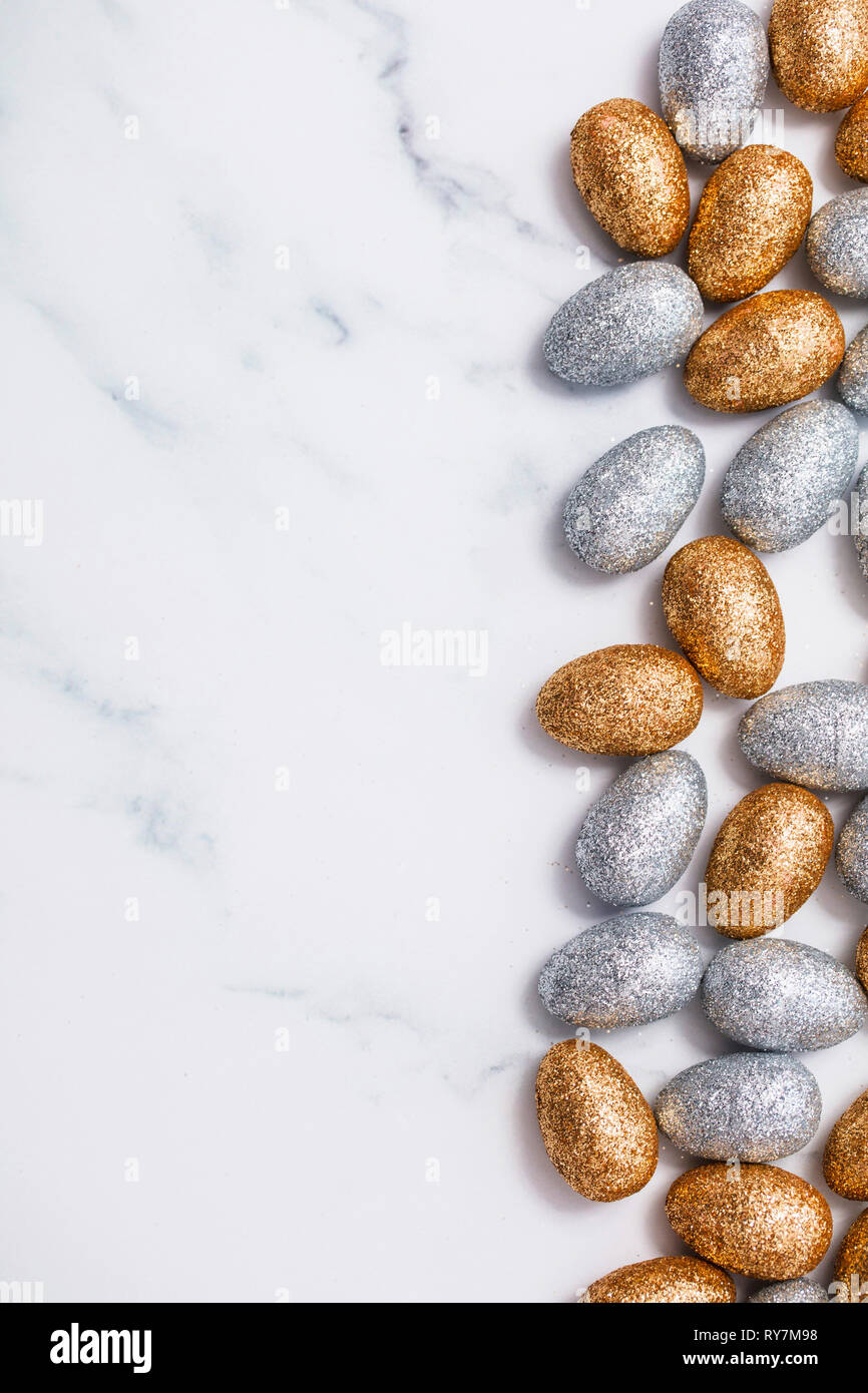 Gold and silver glitter easter eggs on a marble background Stock Photo