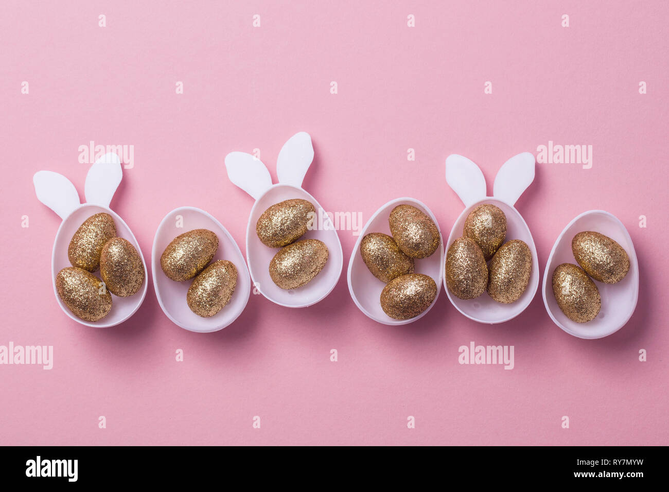 Gold glitter eggs in a white easter bunny egg shape with ears Stock Photo