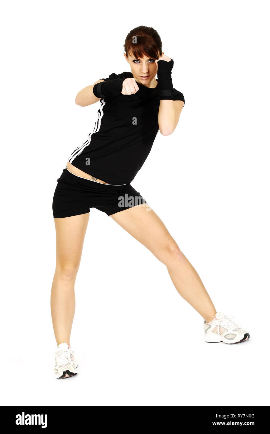 A young woman is training martial arts. Isolated in front of a white background. Stock Photo