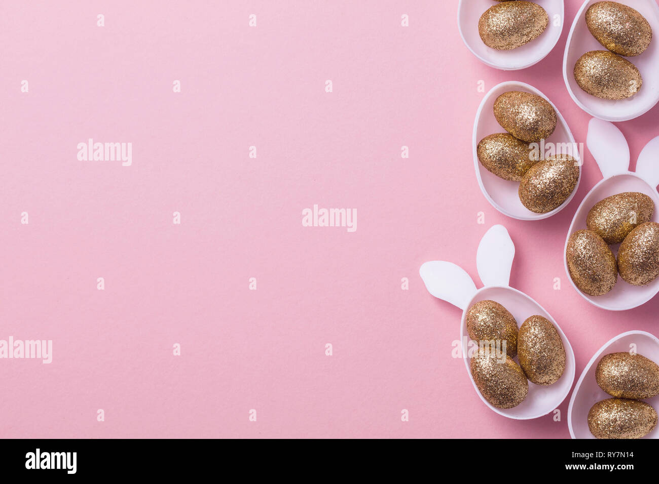 Gold glitter eggs in a white easter bunny egg shape with ears Stock