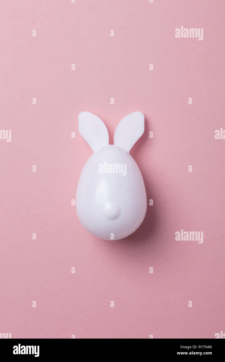 Easter egg with bunny ears on a pastel pink background Stock Photo
