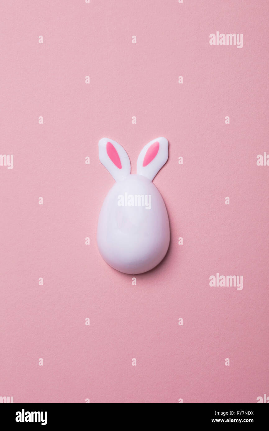 Easter egg with bunny ears on a pastel pink background Stock Photo