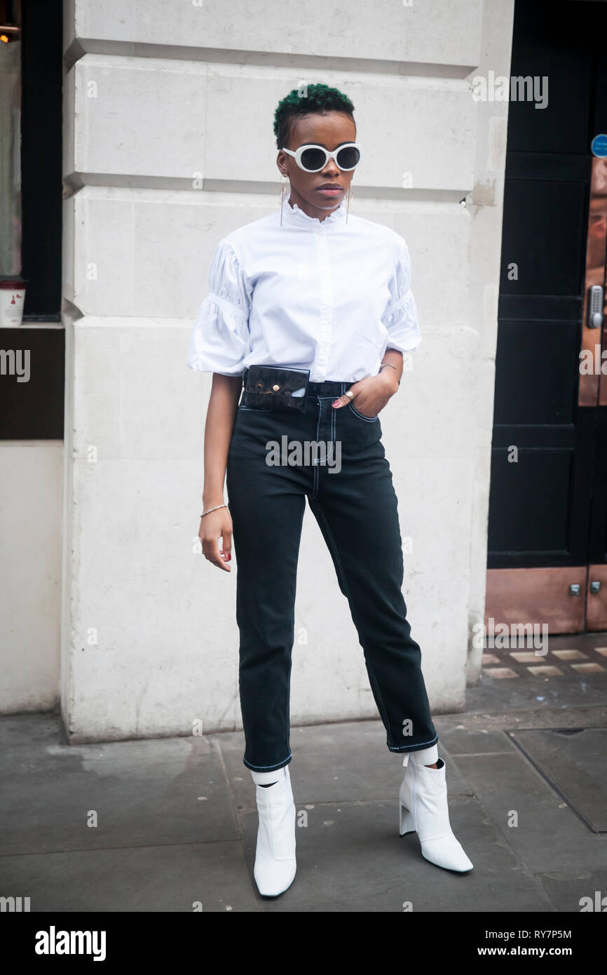 LONDON FEBRUARY 17 2019 Stylish attendees gathering outside 180 The Strand for London Fashion Week. Girl in white shirt and black jeans Stock Photo Alamy