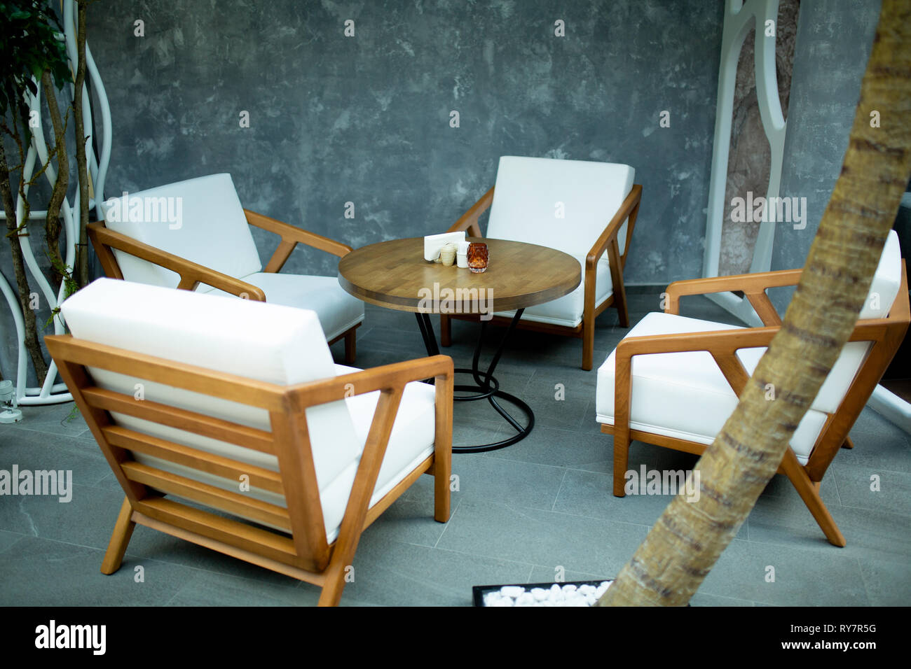 A cozy place to meet with a round table, white chairs Stock Photo - Alamy