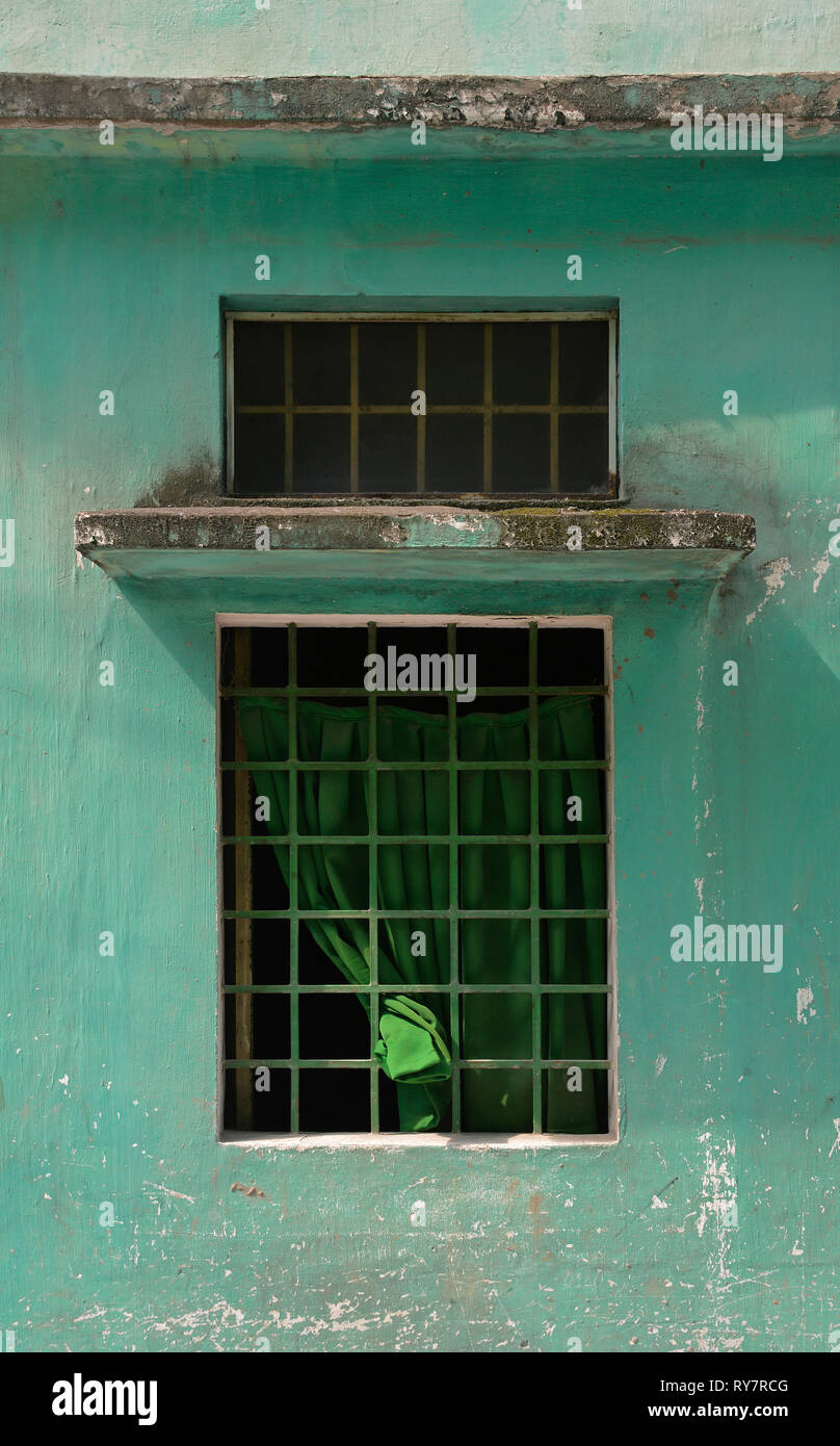 A window in a green wall near in the Tran Hung Dao Alleys in District 1, Saigon, Vietnam Stock Photo