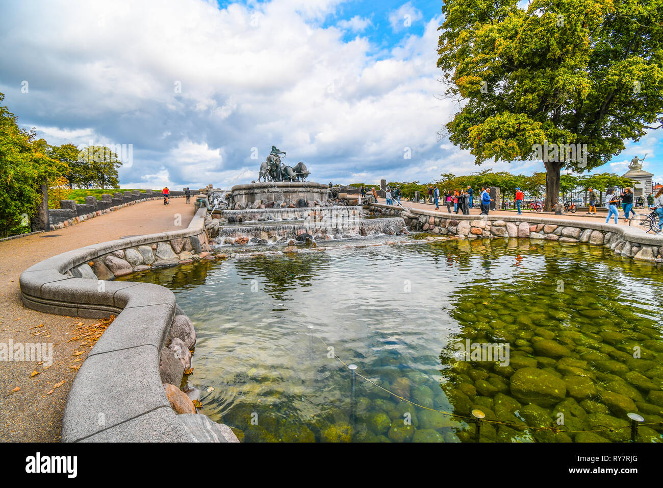Tourists visit the Gefion Fountain featuring a large scale group of oxen driven by the Norse Goddess Gefjon in Langelinie Park, Copenhagen, Denmark. Stock Photo
