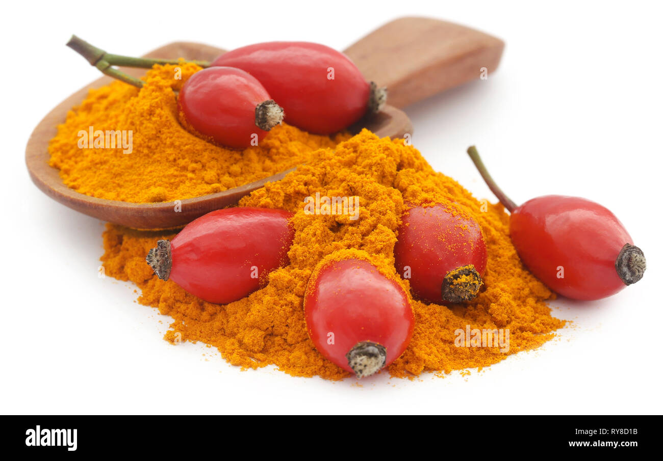 Rose hip powder with fruits, medicinal herbs over white background Stock Photo