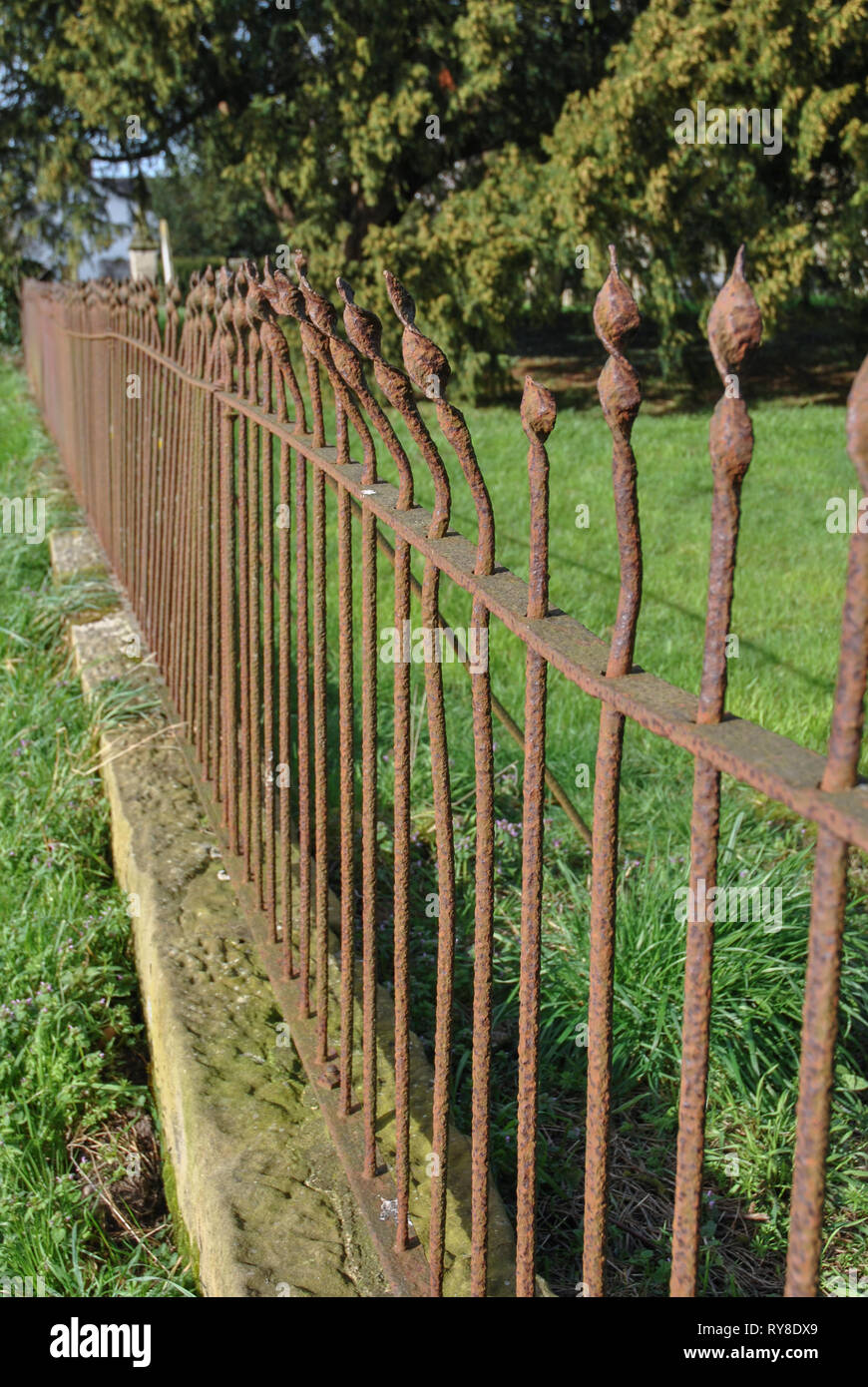 An old rusted bent iron fence with spike design Stock Photo Alamy