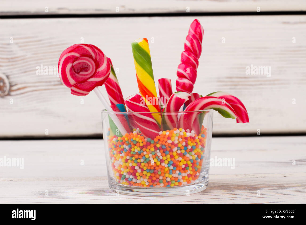 Glass container with lollipops, candy canes and sprinkles. Stock Photo