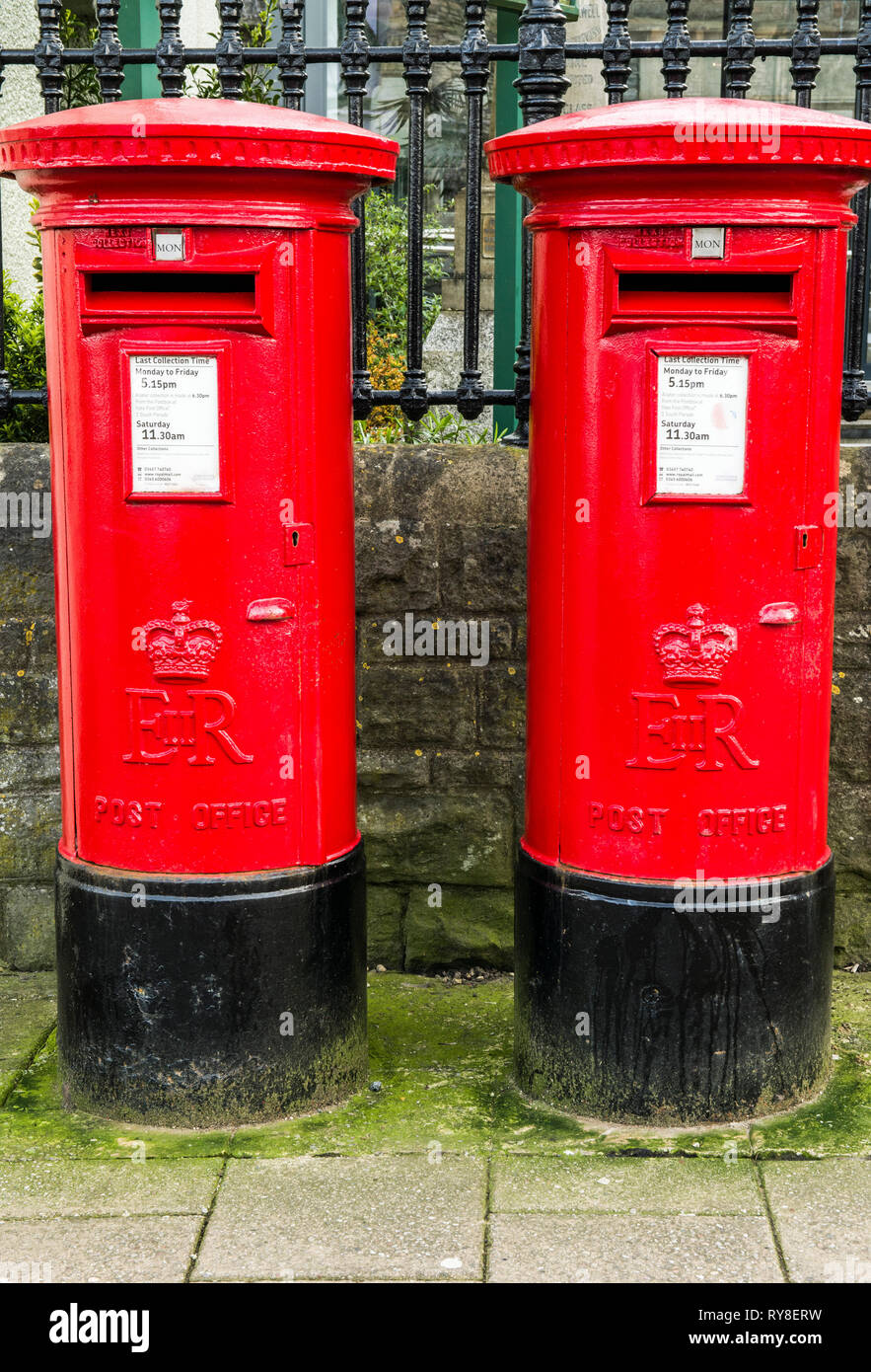 Two Red Cylindrical Pillar Boxes side by side on the High Street in Chipping Sodbury, South Gloucestershire, England, UK Stock Photo