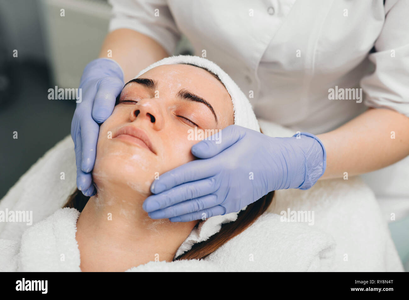 beautiful woman having her face pampered at beauty salon by her beautician Stock Photo