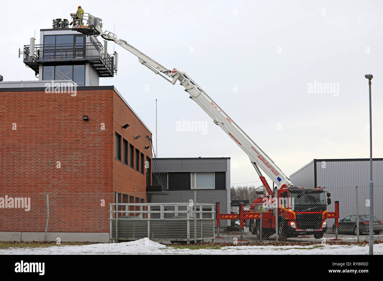 Salo, Finland - March 3, 2019: Fireman operating Volvo FE fire truck mounted Bronto F42RLX Skylift aerial ladder platform in Salo, Finland. Stock Photo
