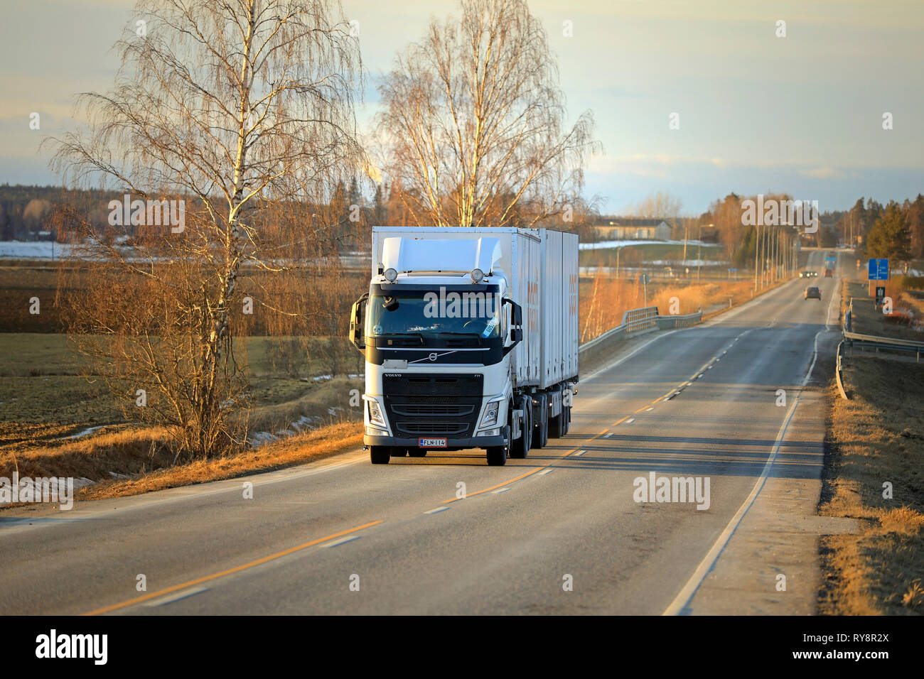 Salo, Finland - March 1, 2019: White Volvo FH truck double trailer for Posti Group, Finnish postal service on highway at sunset time in early spring. Stock Photo
