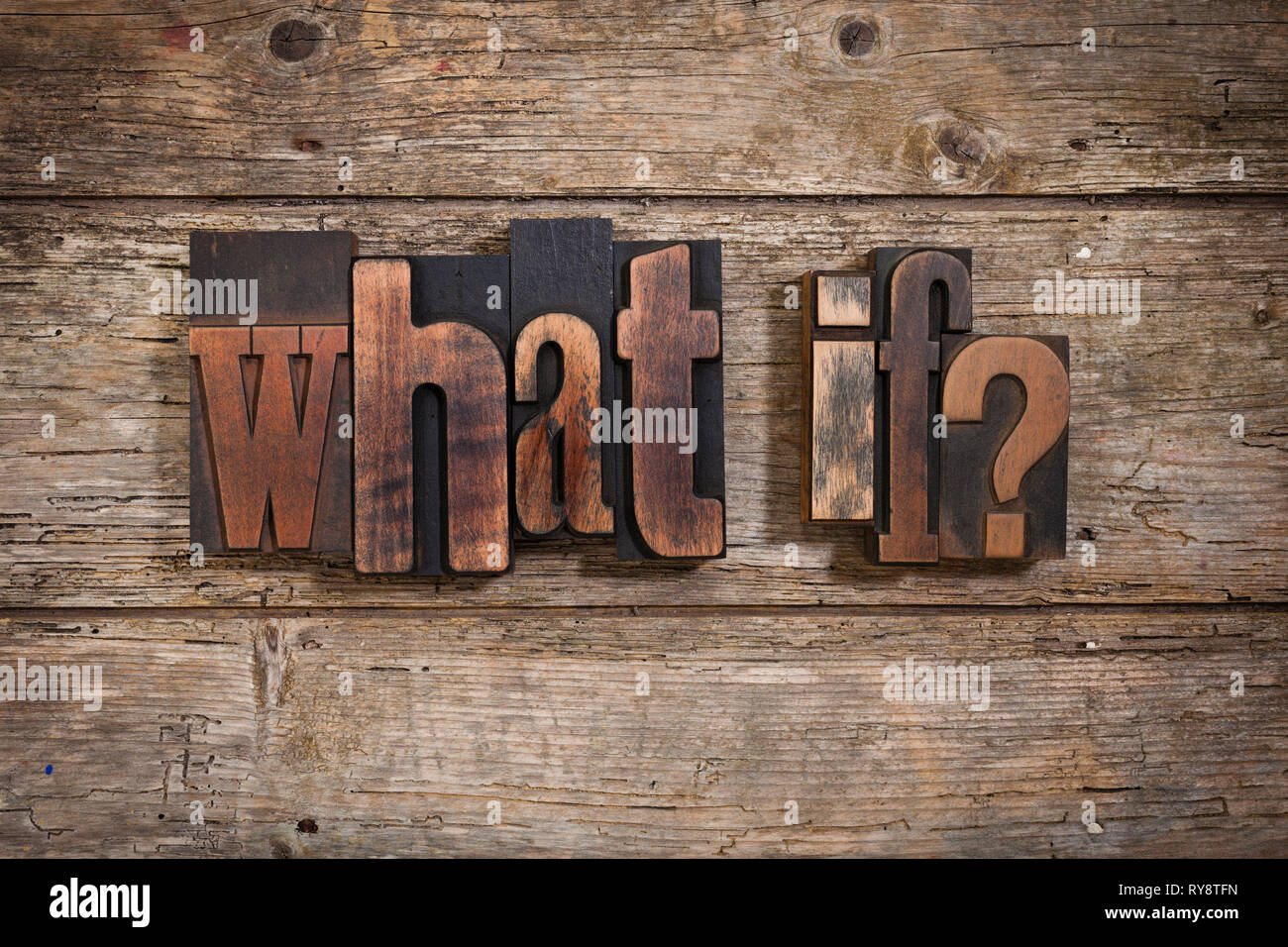 what if, phrase set with vintage letterpress printing blocks on rustic wooden background Stock Photo