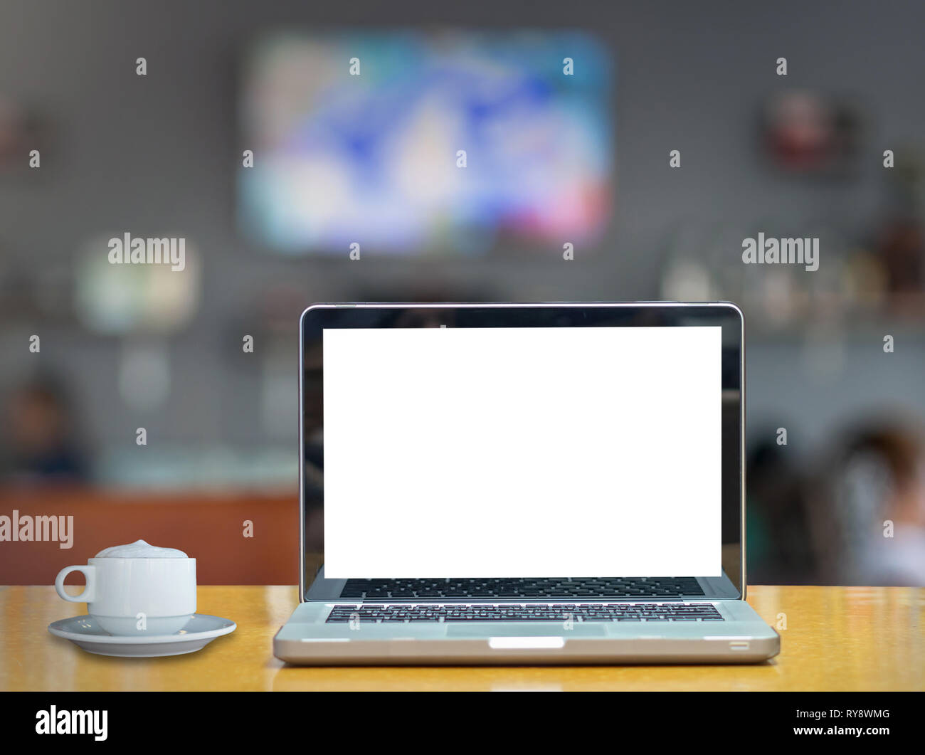 Laptop On The Wood Table Over The Coffee Shop Blurred Background
