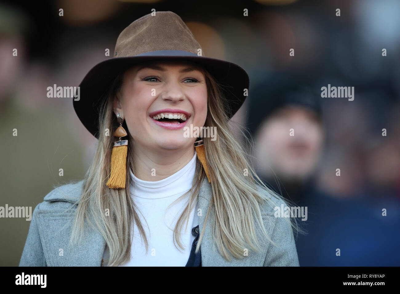 A racegoer watches a horse race during Champion Day of the 2019 Cheltenham Festival at Cheltenham Racecourse. Stock Photo