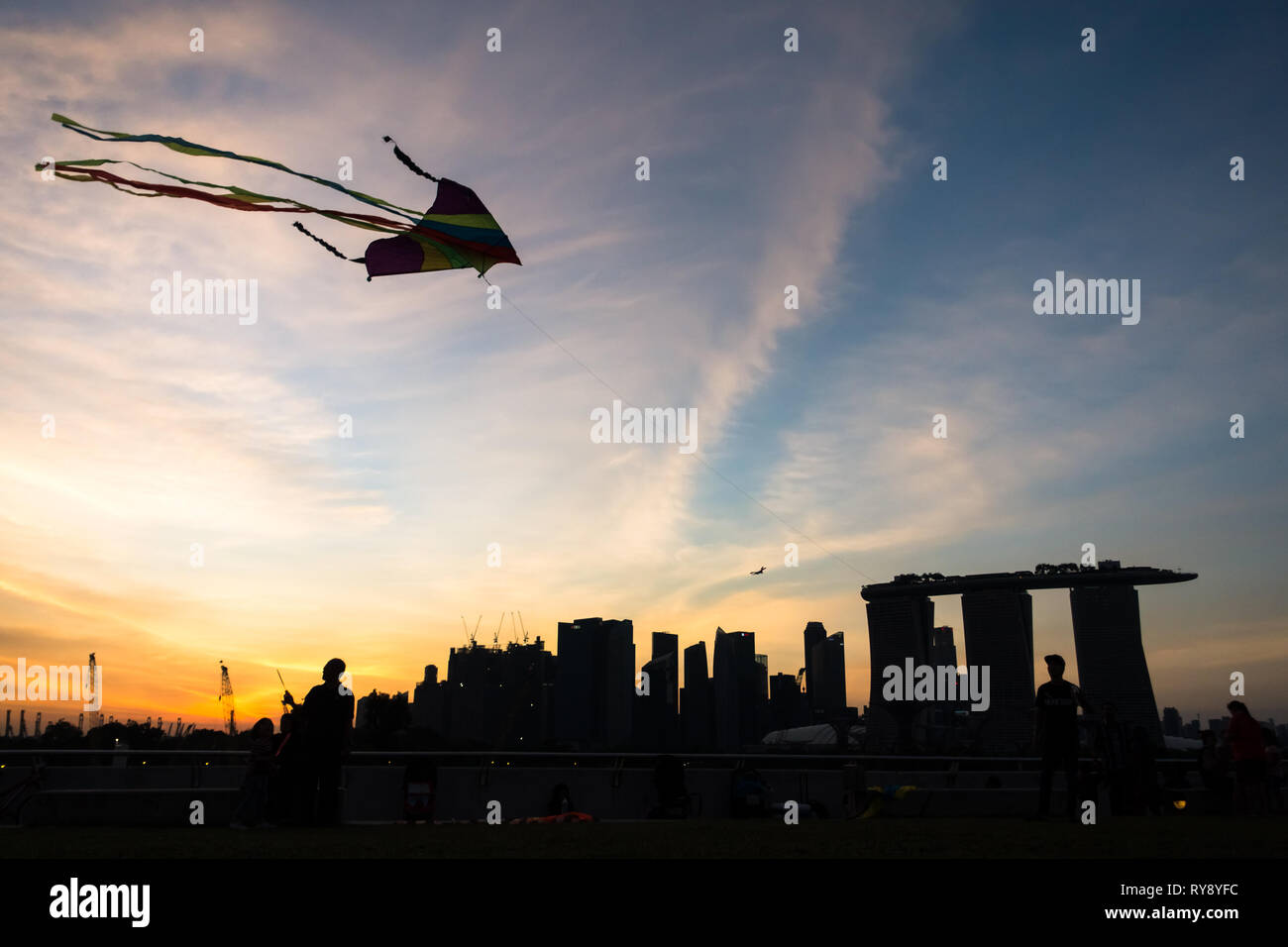 Kite flying silhouette and Marina Bay Sands Sunset View - Marina Barrage -Singapore Stock Photo