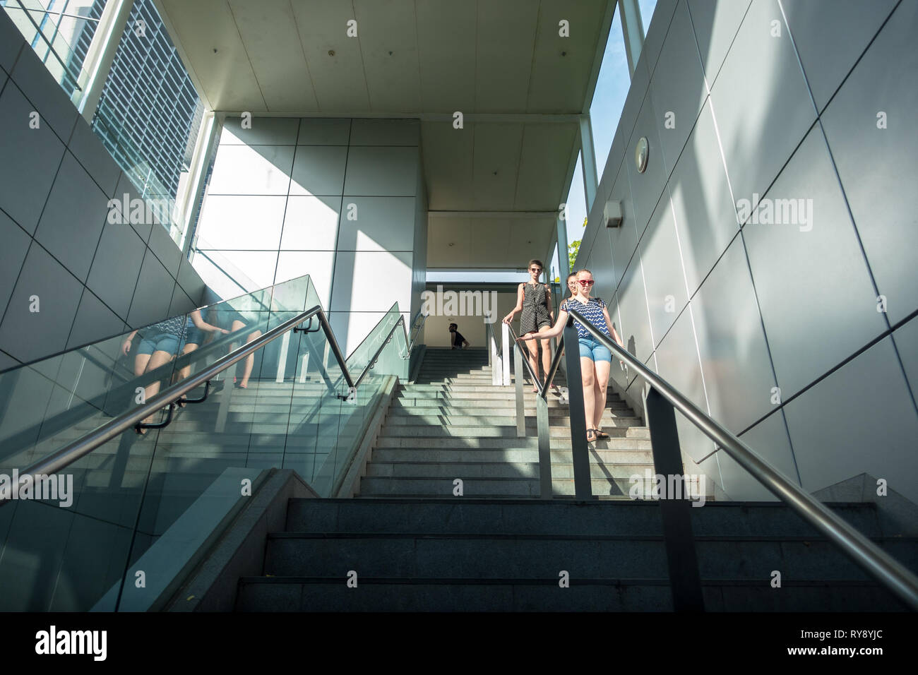 Diverse Tourist Women Exiting Stairs at MRT Station, Singapore Stock Photo