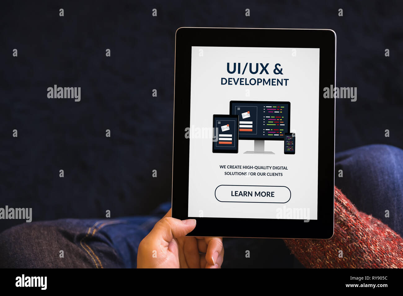 Hands holding digital tablet computer with UI/UX design and development concept on screen. All screen content is designed by me. Top view Stock Photo