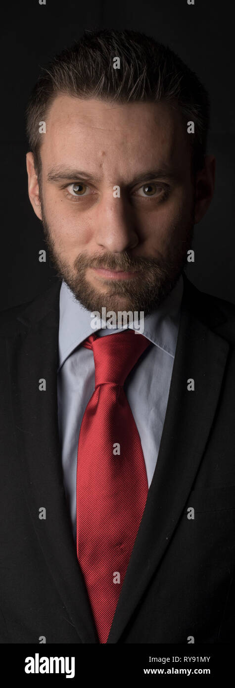 Portrait of a young male man with suit and red cravat Stock Photo