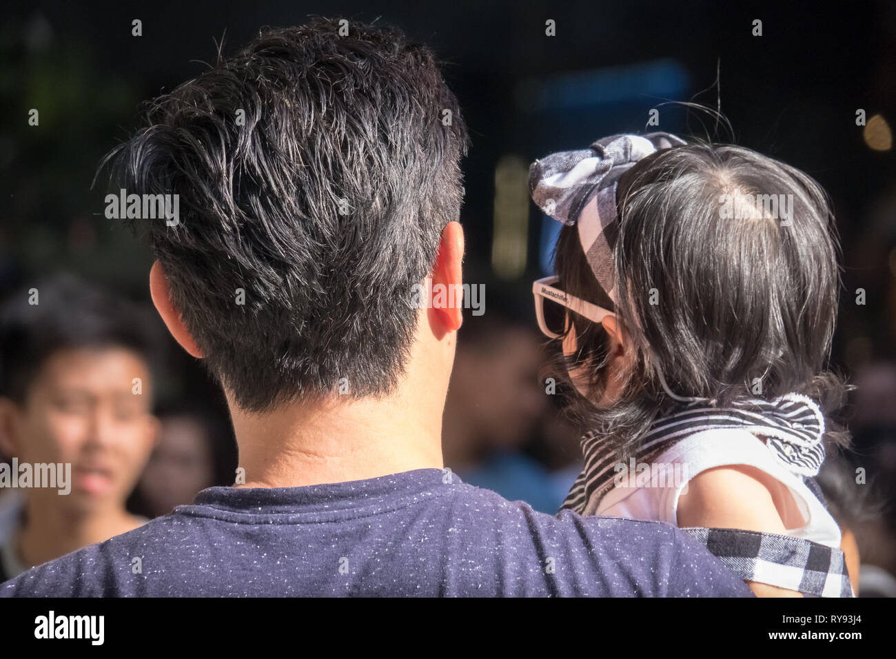 Young Asian Dad Holding his Baby Daughter, Closeup from behind - Orchard Road, Singapore Stock Photo