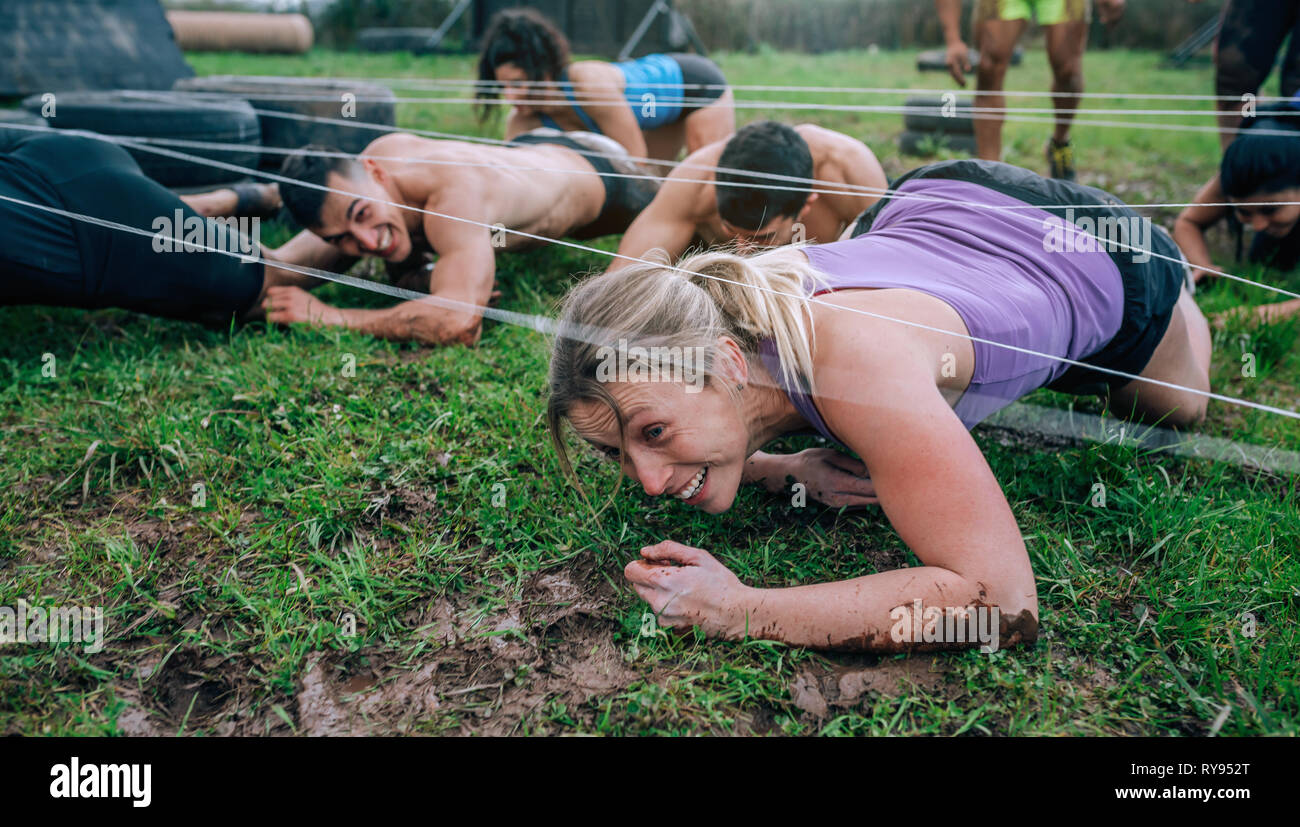 Participants in an obstacle course crawling Stock Photo