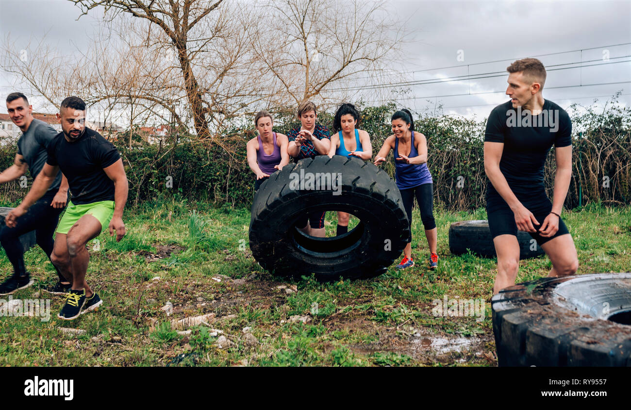 Female participants in an obstacle course turning a wheel Stock Photo