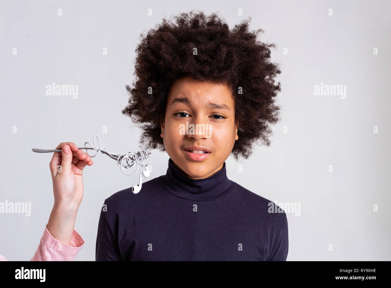 Dark-haired curly boy looking confused of situation Stock Photo