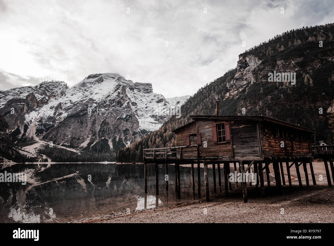 Wooden Cabin On Stilts On Coast Near Amazing Lake And Stone High