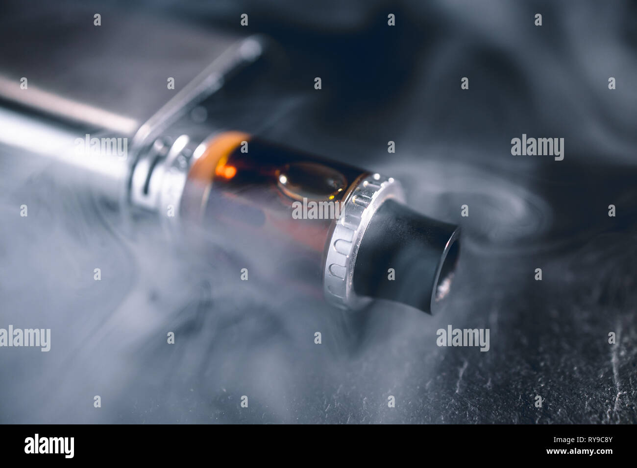Vape pen metal electronic cigarette with vaping smoke cloud dark background  Stock Photo - Alamy