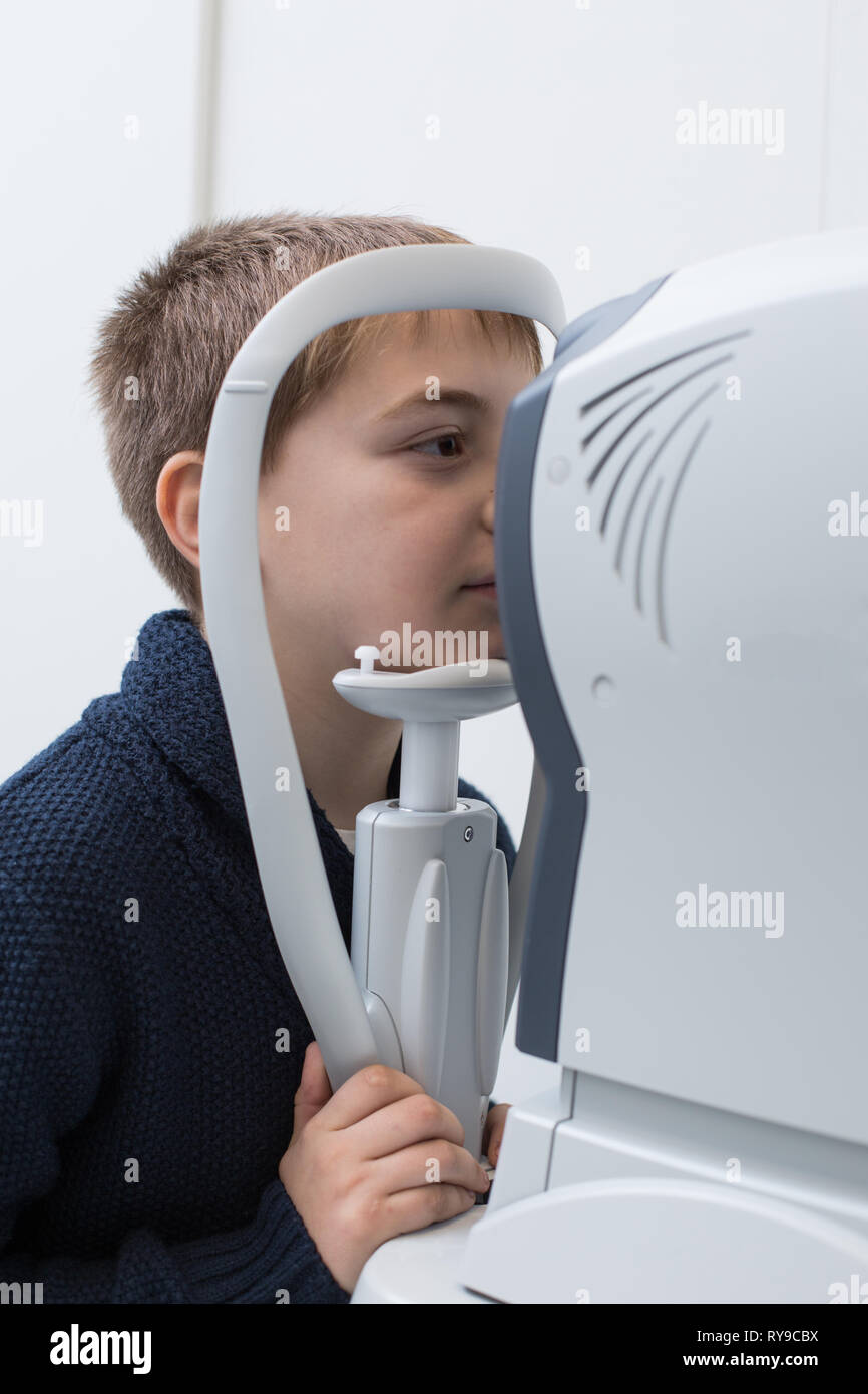 Eye Testing Boy Optician testing a boy's eyes with optometry devices Stock Photo - Alamy
