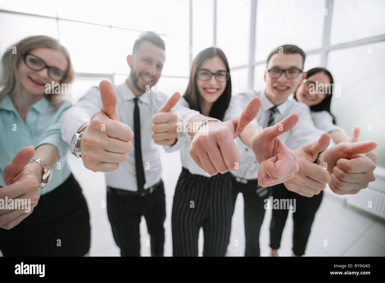 close up. business team showing their thumbs up Stock Photo - Alamy