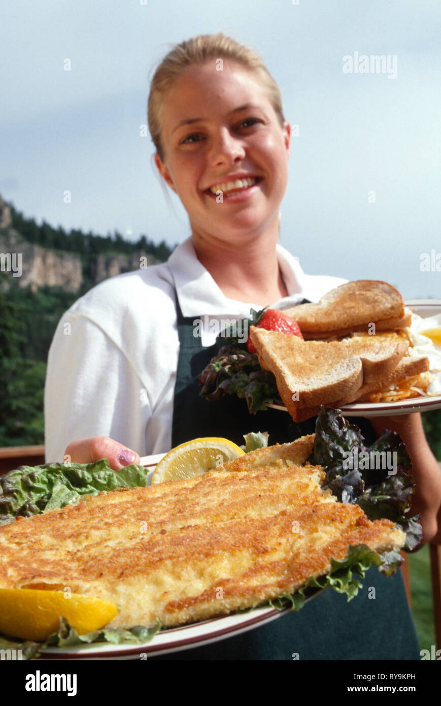 Young Waitress Delivers a Fried Fish and Eggs Breakfast Platter