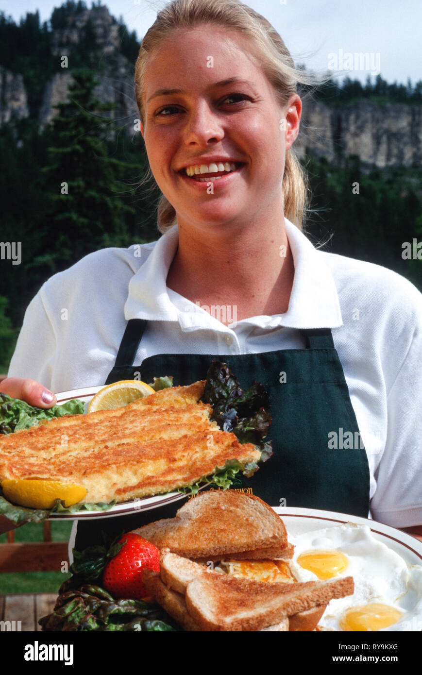 Young Waitress Delivers a Fried Fish and Eggs Breakfast Platter