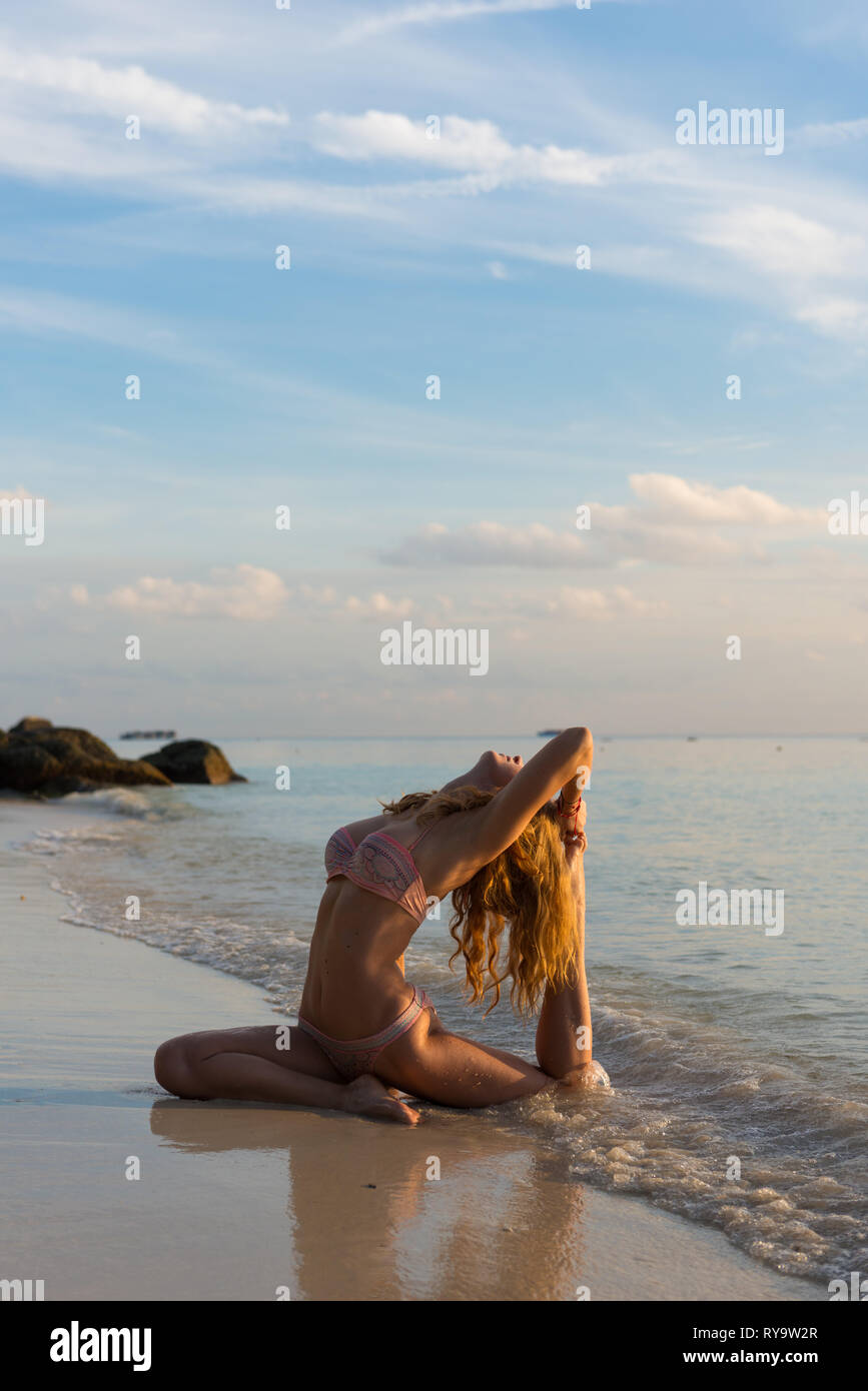 Beach yoga in Ko Lipe island Thailand, girl in pigeon pose Stock Photo