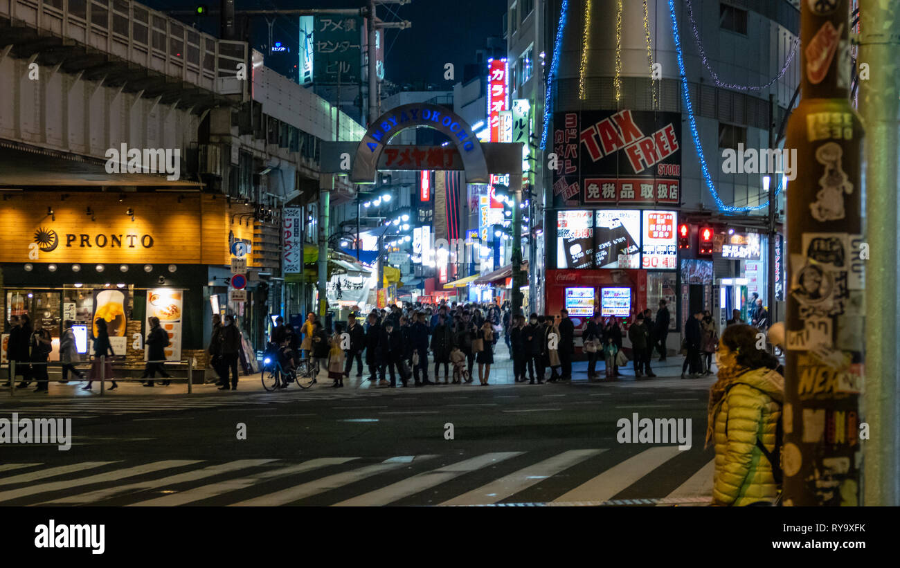 TOKYO, JAPAN - FEBRUARY 7, 2019: People in Ameyoko or Ameyayokocho market near Ueno station. A major shopping street in Tokyo. Japanese text advertise Stock Photo