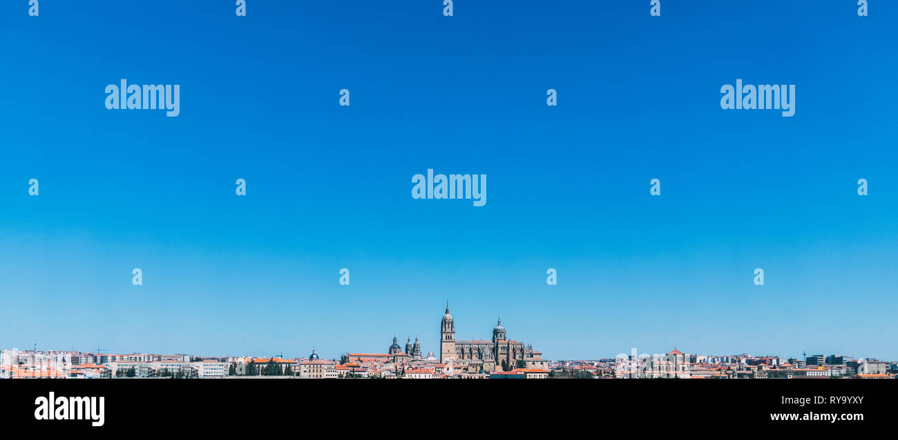 Distant panoramic view of Salamanca skyline on a beautiful blue sky day. Catedral de Salamanca sits centre, orange city rooftops across the cityscape Stock Photo