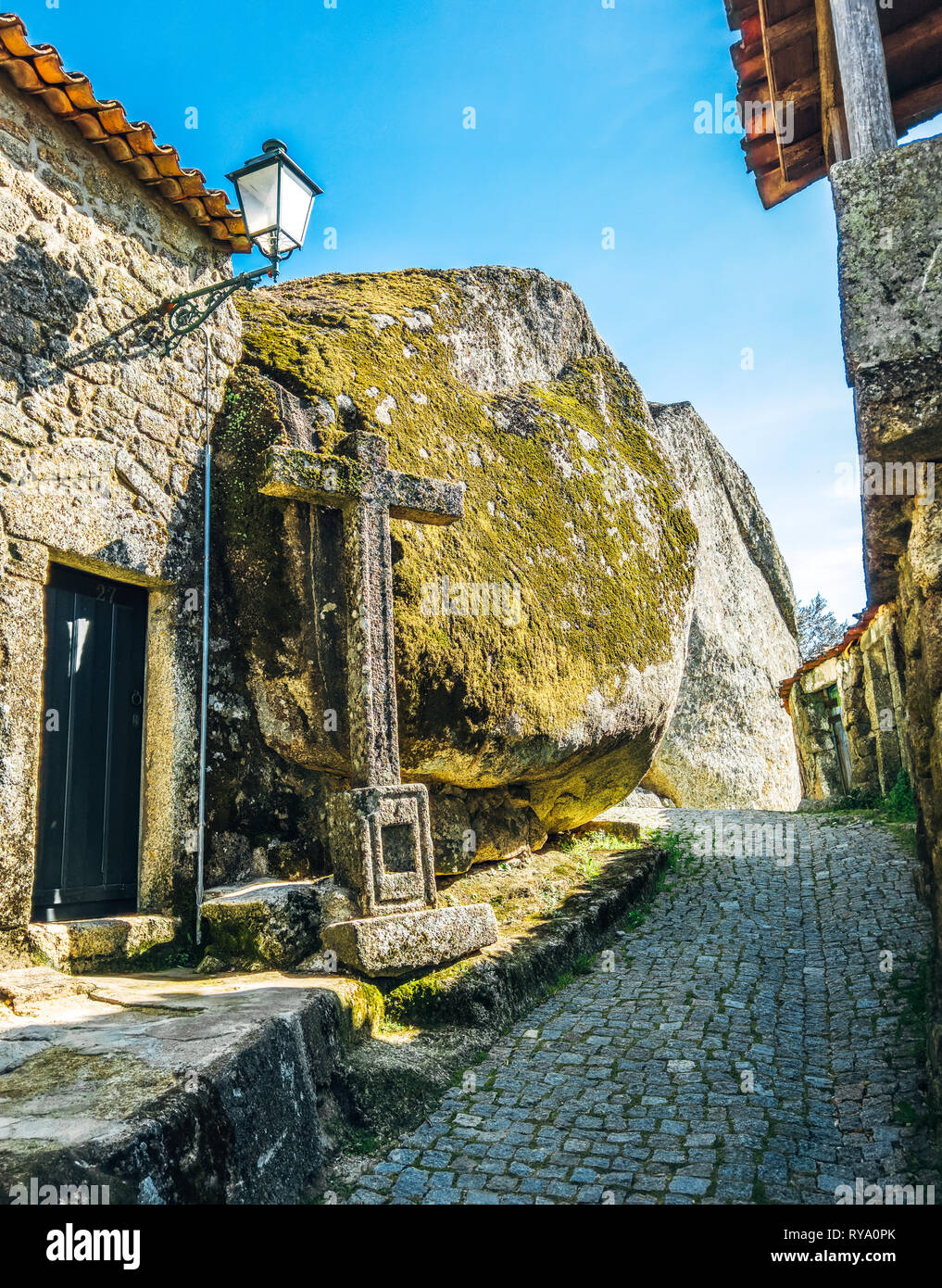 Looking up a narrow cobbled street in the ancient granite boulder village of Monsanto. Gigantic Boulder houses of a hilltop town. Amazing architecture Stock Photo