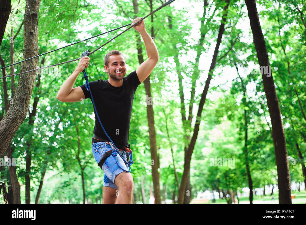 Hiking in the rope park beautiful sports guy Stock Photo Alamy