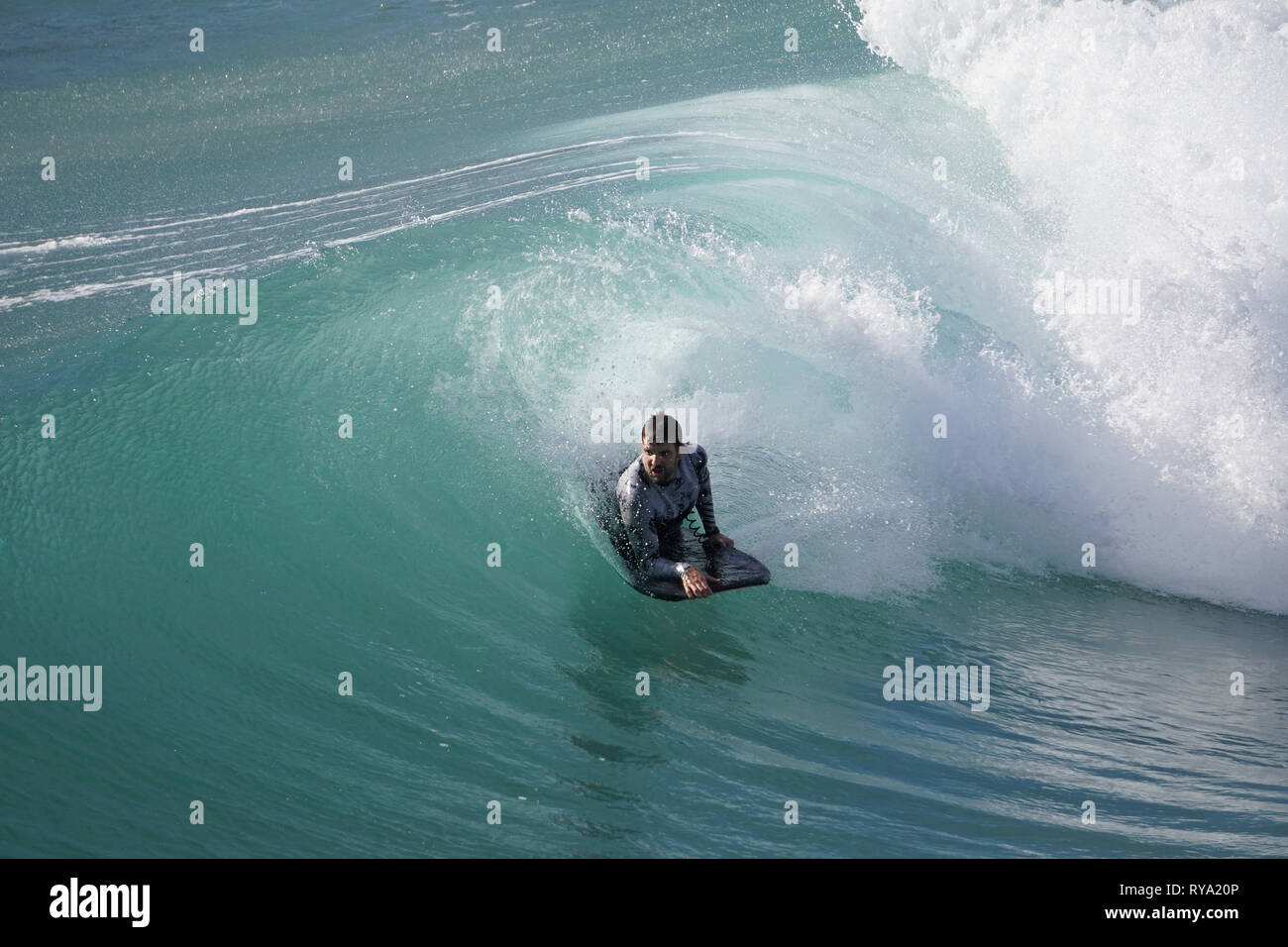Surfer riding the crest of a wave on an azure ocean Stock Photo - Alamy