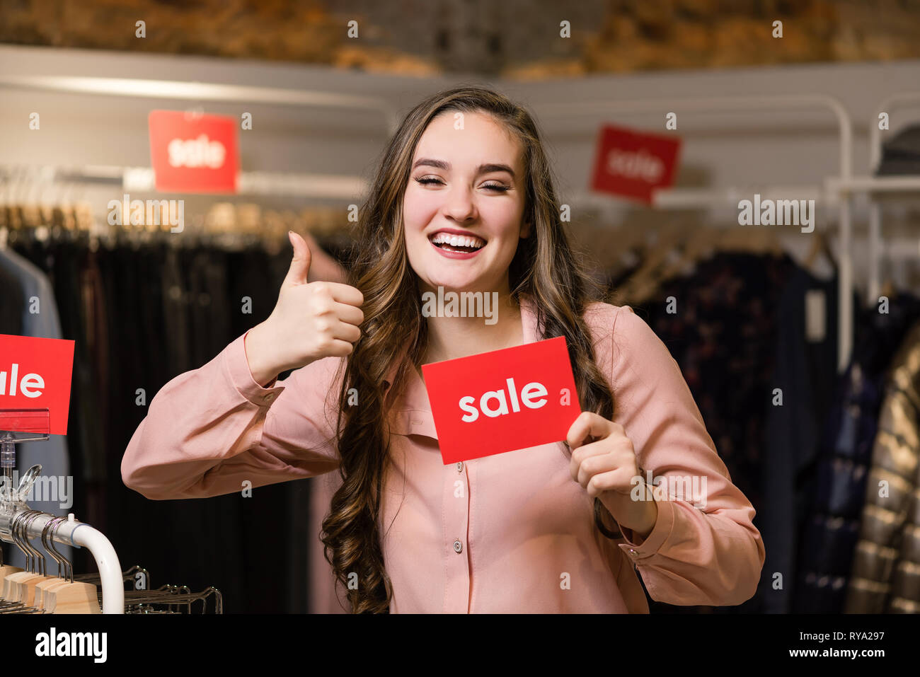 Young smiling brunette woman showing thumb up Stock Photo