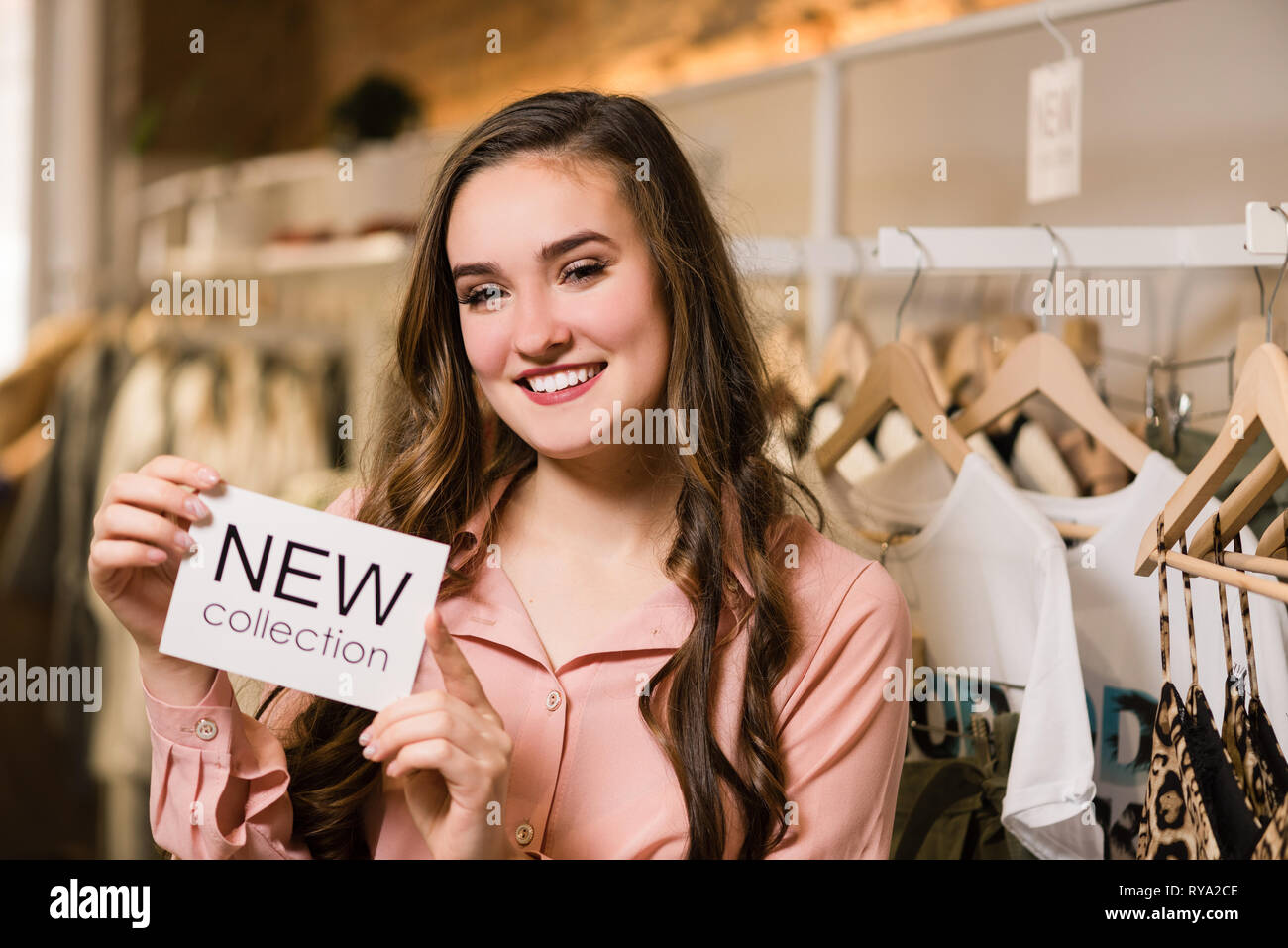 Smiling brunette woman with new collection words. Stock Photo