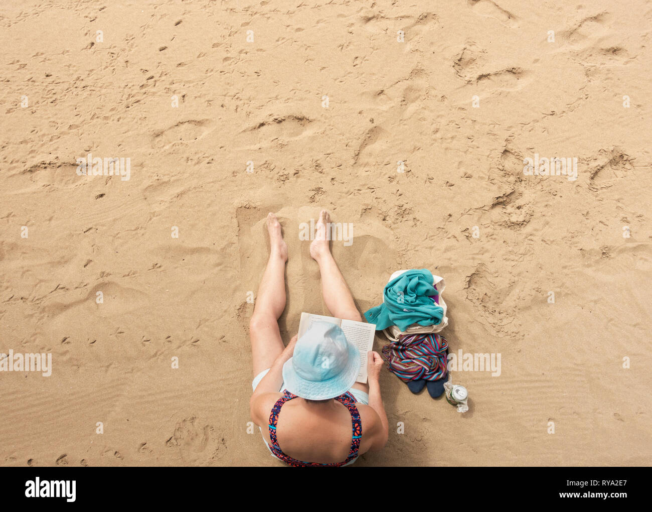 Woman reading book on beach. Stock Photo