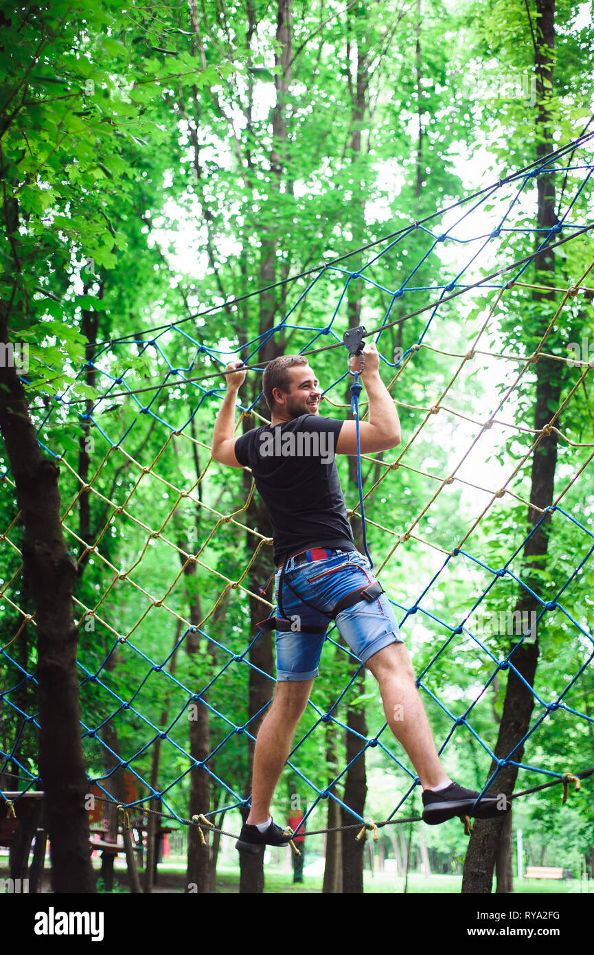 Hiking in the rope park beautiful sports guy Stock Photo Alamy