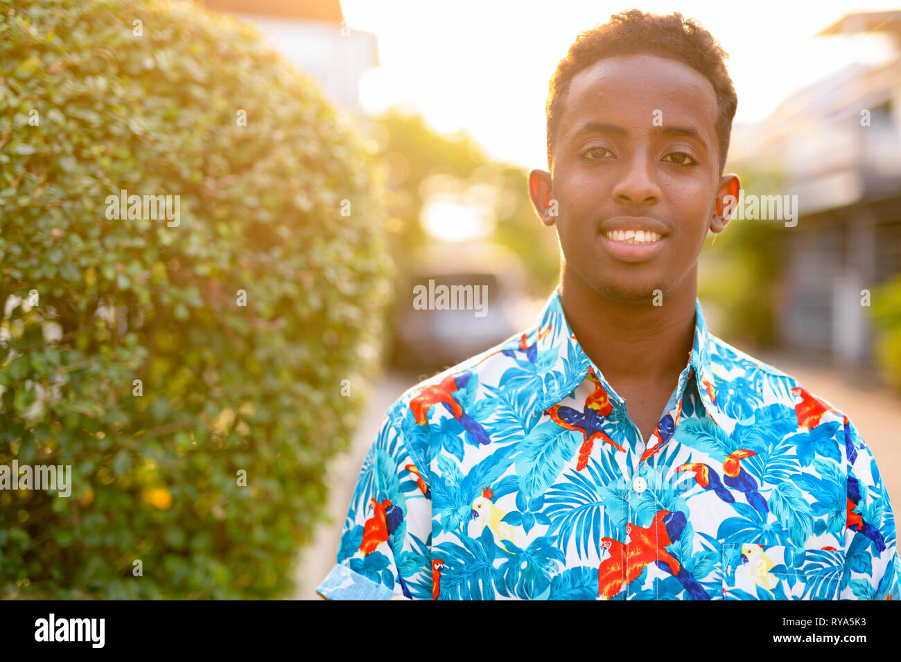 Face of happy young African tourist man smiling outdoors Stock Photo ...