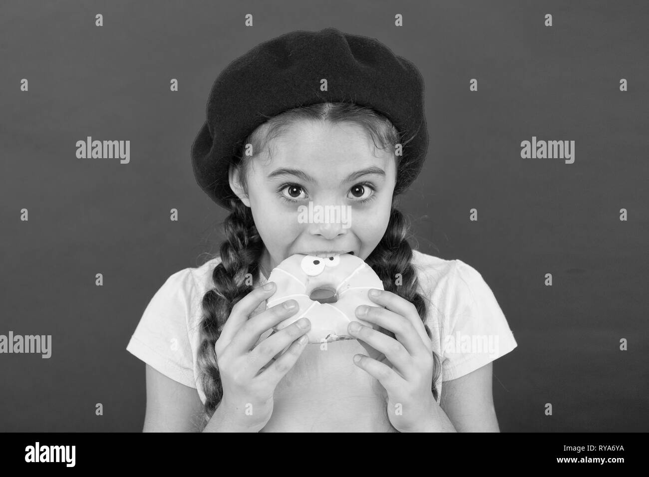 Girl hold glazed cute donut in hand red background. Kid playful girl