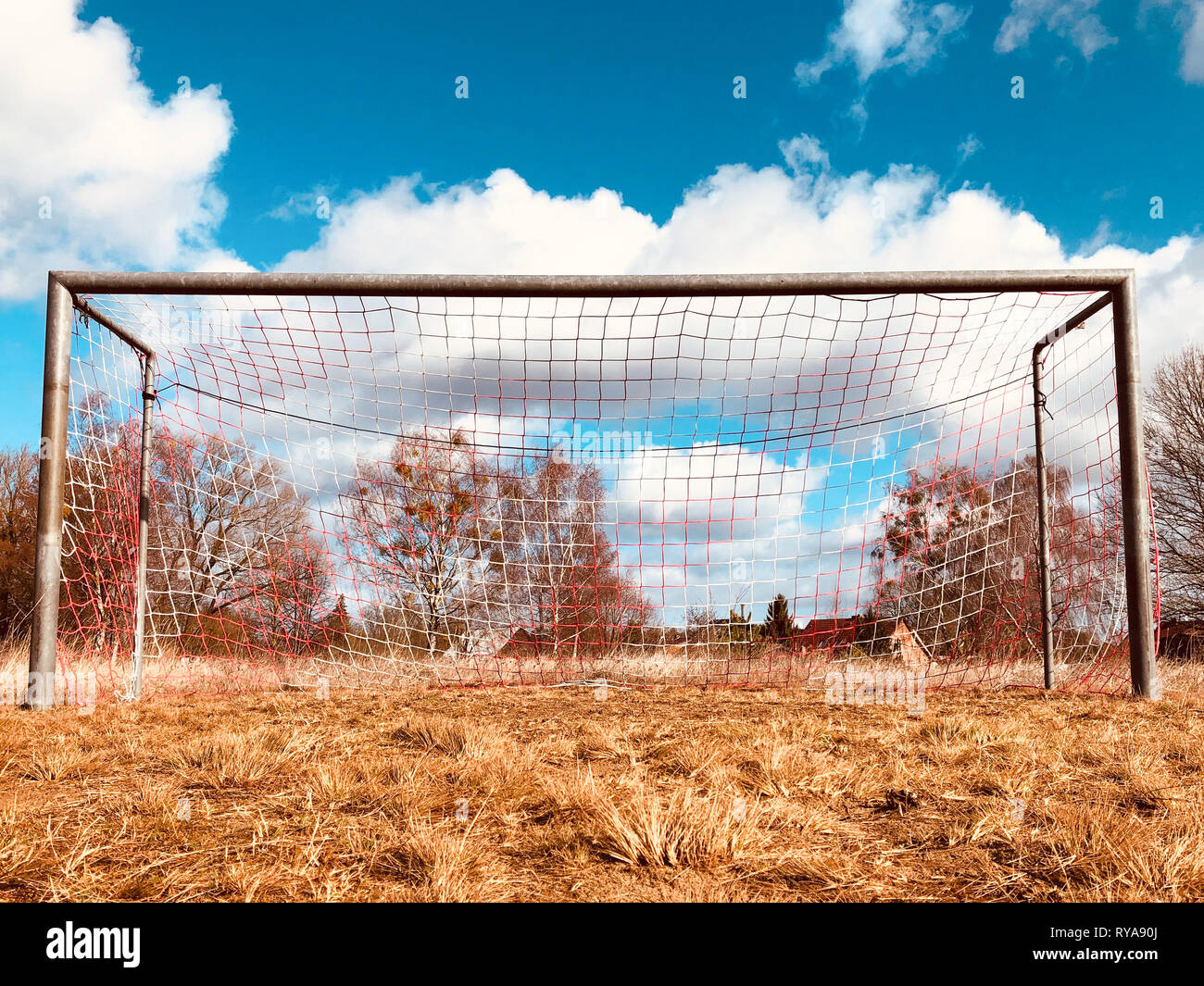 soccer goal on countryside, low angle view of rural soccer field - Stock Photo
